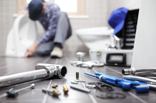 Plumber repairing a running toilet in a Toronto home
